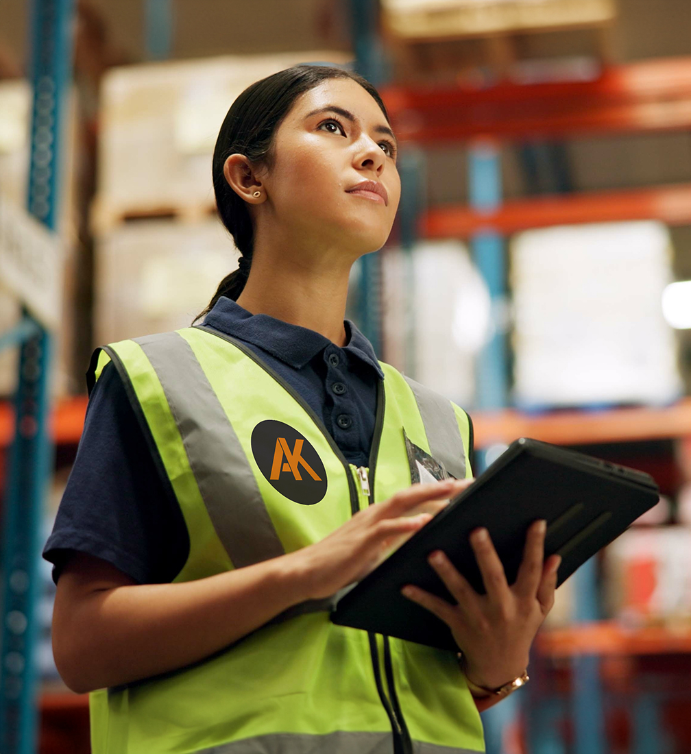 a woman in a safety vest in packaging warehouse
